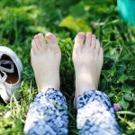 a person laying in the grass with their feet up