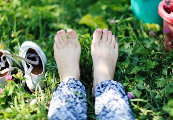 a person laying in the grass with their feet up