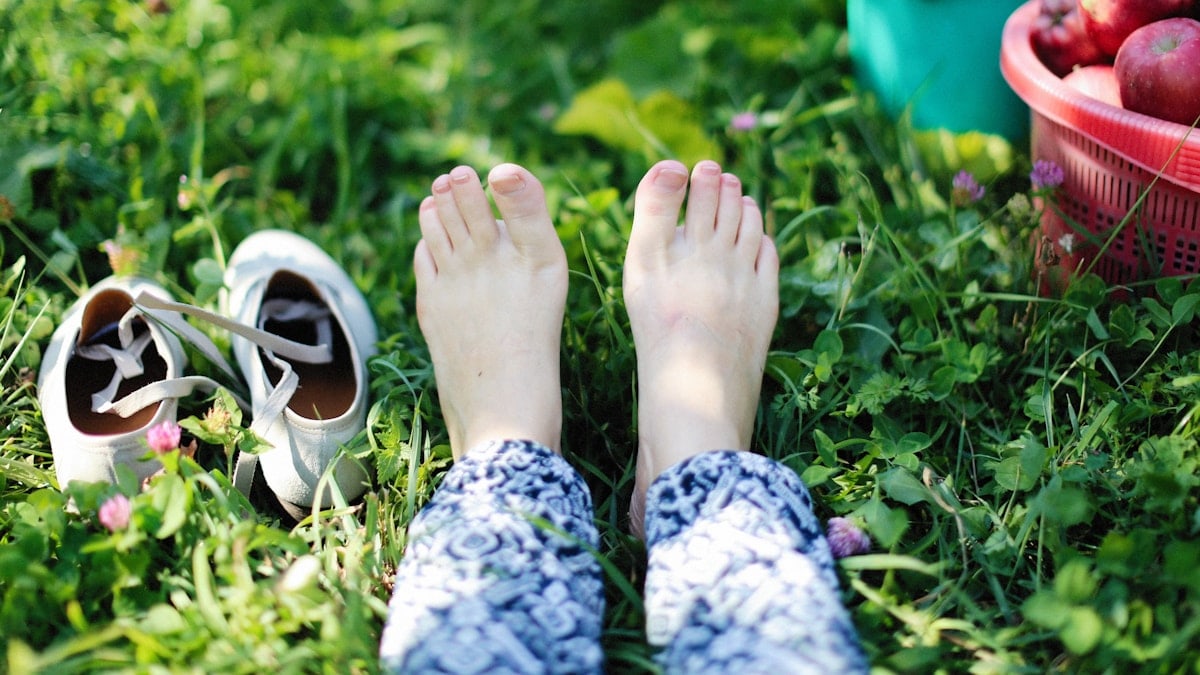 a person laying in the grass with their feet up