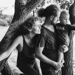 A joyful family enjoying a day by the lake, under the trees.