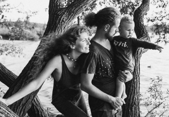 A joyful family enjoying a day by the lake, under the trees.