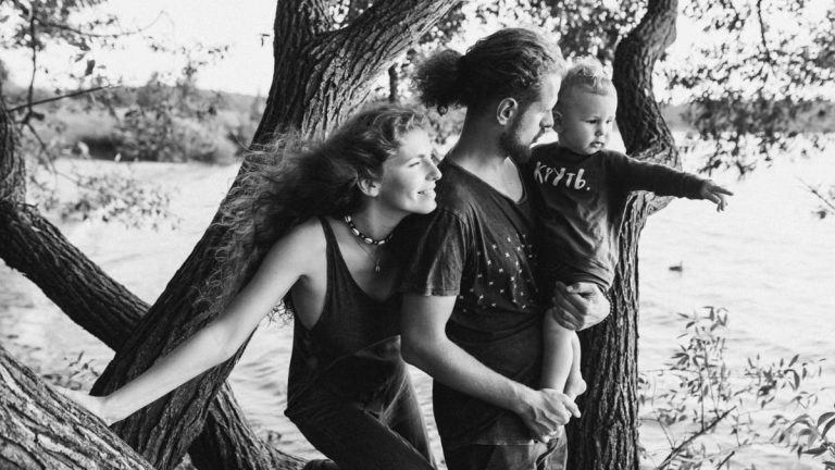 A joyful family enjoying a day by the lake, under the trees.